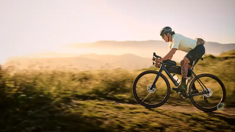 Ein JobRadler fährt an der Küste ein Trek Gravelbike im Sonnenuntergang
