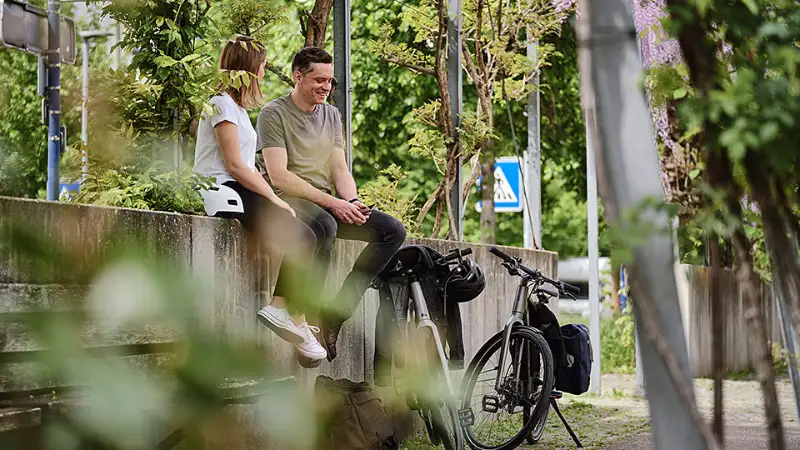 Zwei Radlerinnen sitzen auf der Mauer grüne Stadt