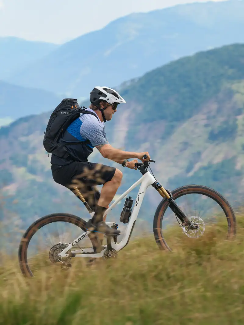Ein Jobradler fährt auf einem Cube-Mountainbike von Multicycle auf einem Alpentrail