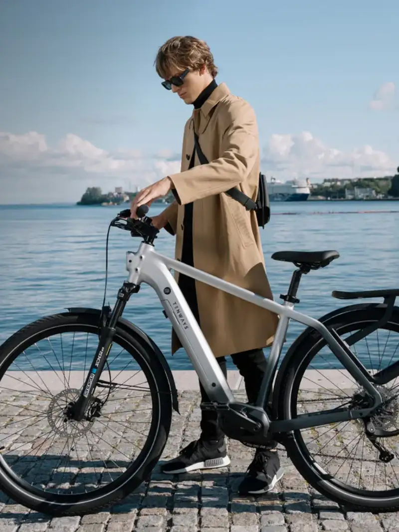 JobRadler auf einem E-Bike von Tenways an einer See-Promenade