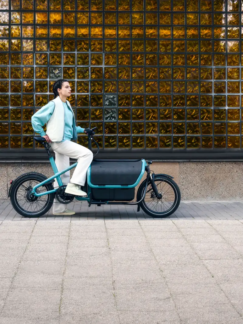 Eine JobRadlerin ist auf ihrem Cargobike von Riese & Müller in der Stadt unterwegs