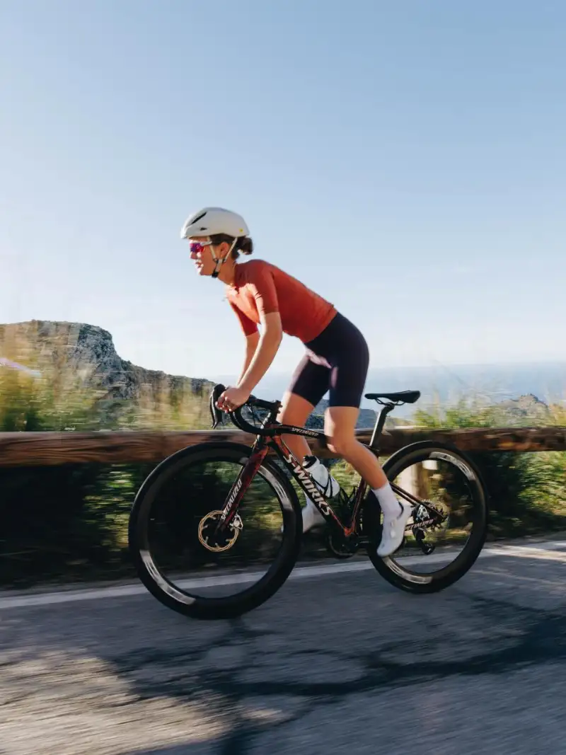 Eine JobRadlerin steht in den Pedalen auf ihrem Rennrad von Specialized