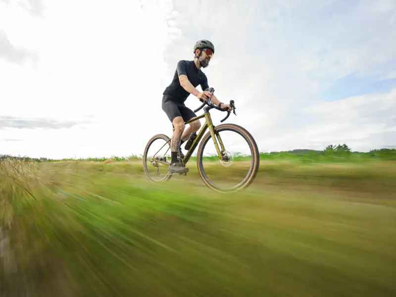 Ein JobRadler fährt sehr schnell auf einem Cube-Fahrrad von Multicycle durch eine Feldlandschaft
