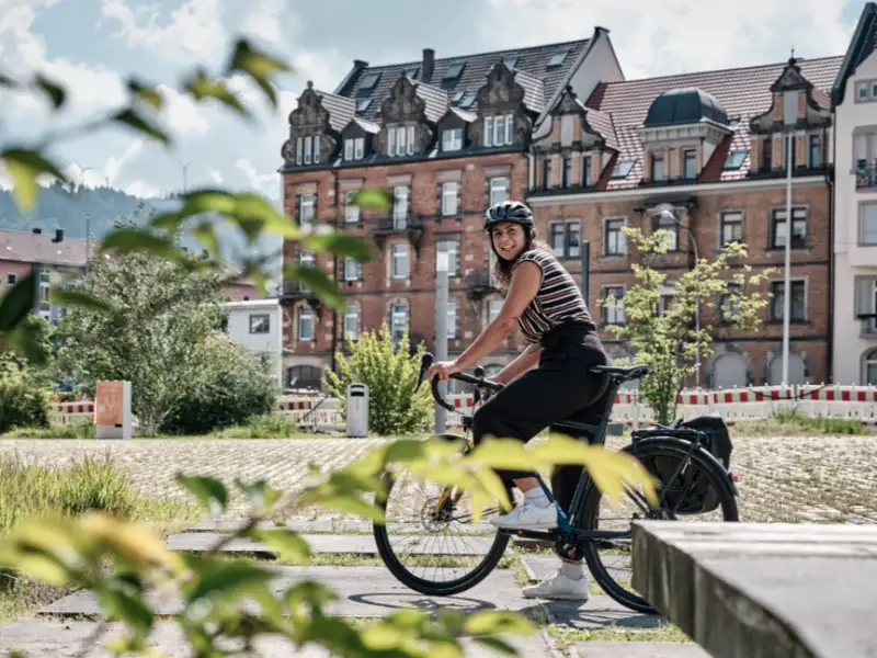 Eine Fahrradfahrerin auf dem Rad im Sommer in der Stadt