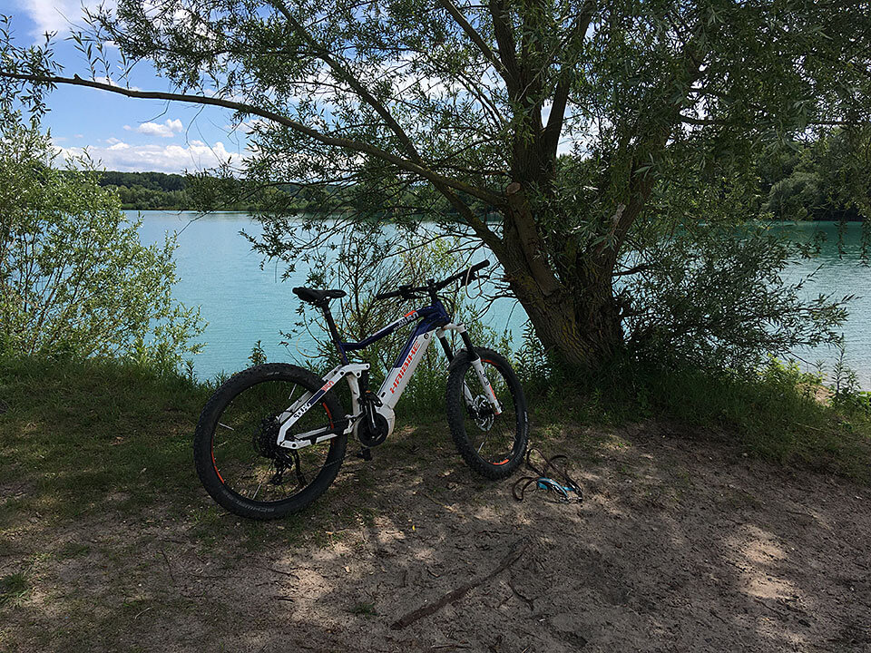 JobRad Moment Michael weißes Fahrrad vor blauem Baggersee