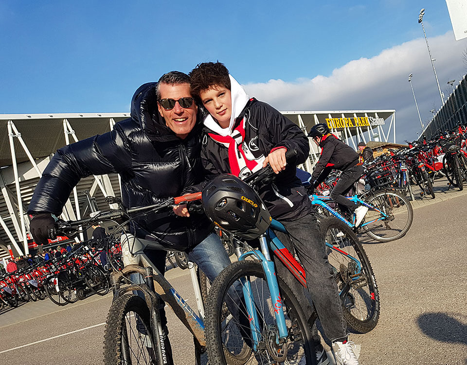 Vater und Sohn radeln als Fahrradfans zum SC