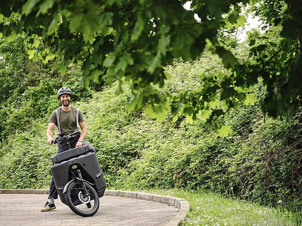 JobRadler mit Lastenrad steht in der Kurve