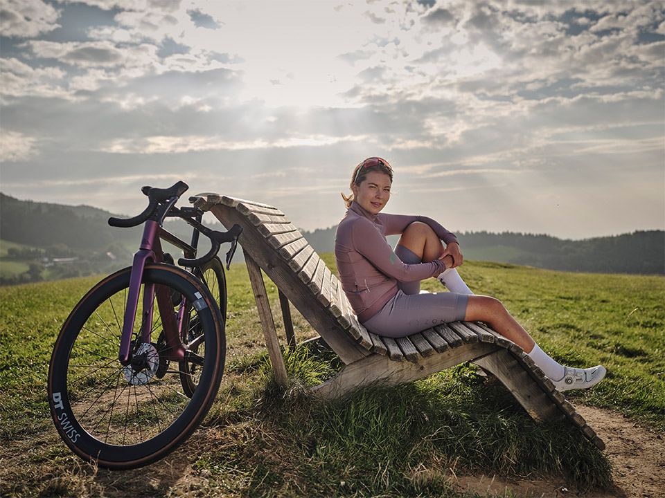 JobRad-Rennradlerin sitzt auf einer Bank und genießt die Aussicht